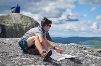 Camper reviewing trail map on top of mountain