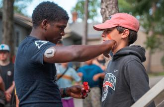 camp staff putting face paint on camper