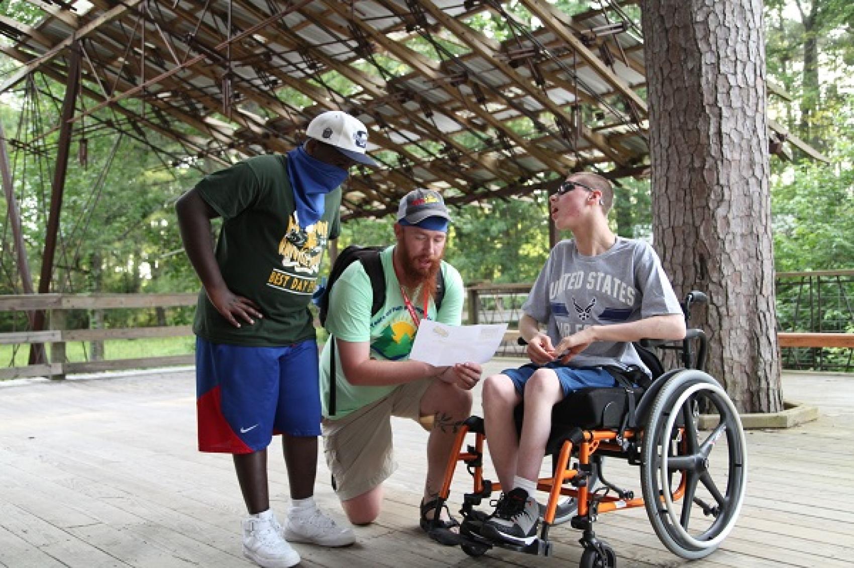 Photo courtesy of MedCamps of Louisiana - staff talking with camper in wheelchair