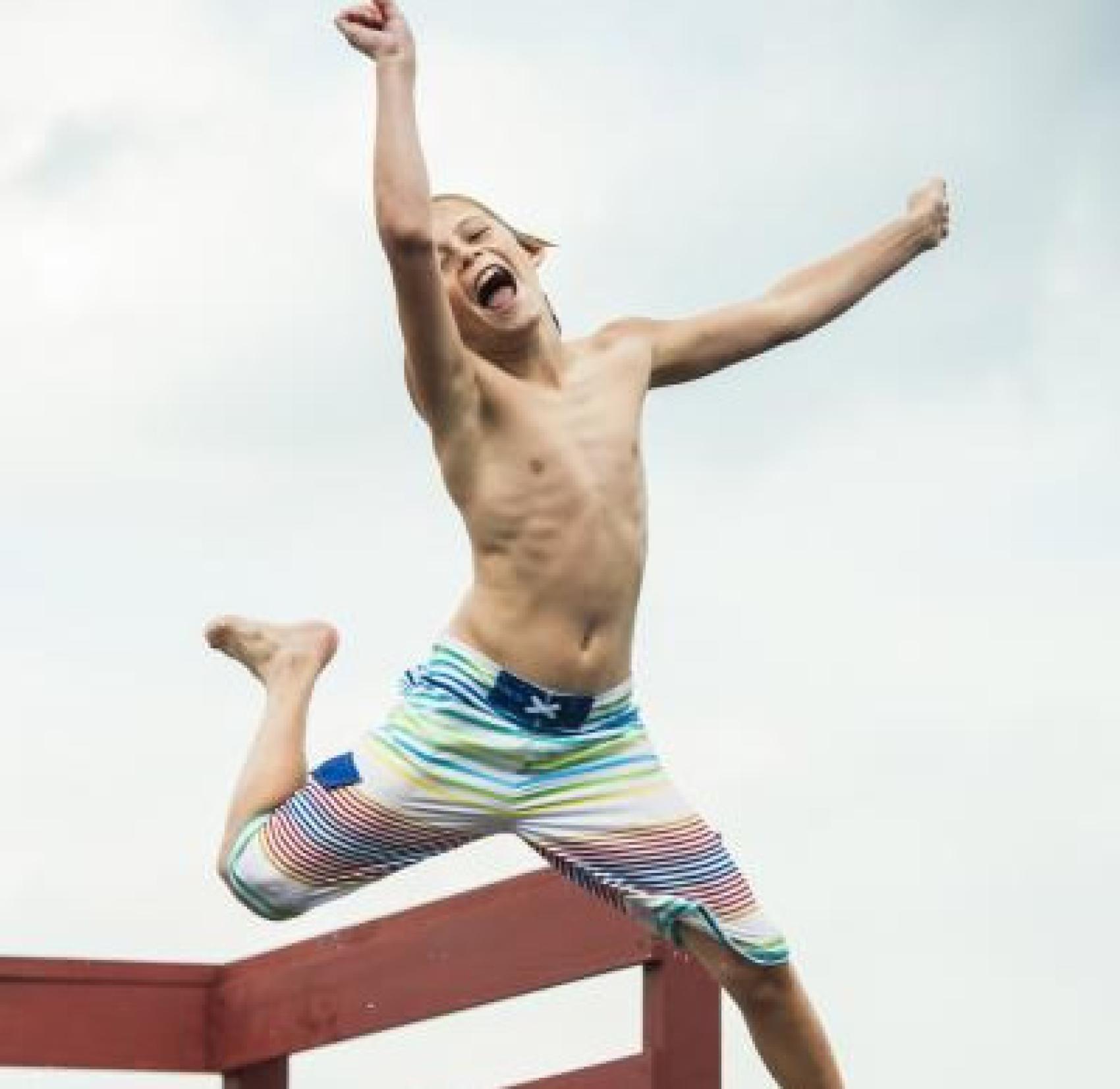 boy jumping into water