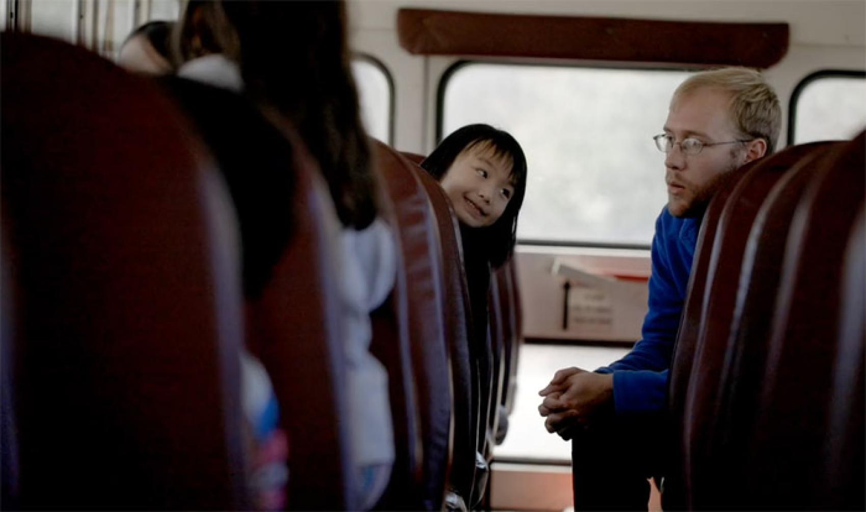 Counselor talking with kids on a bus