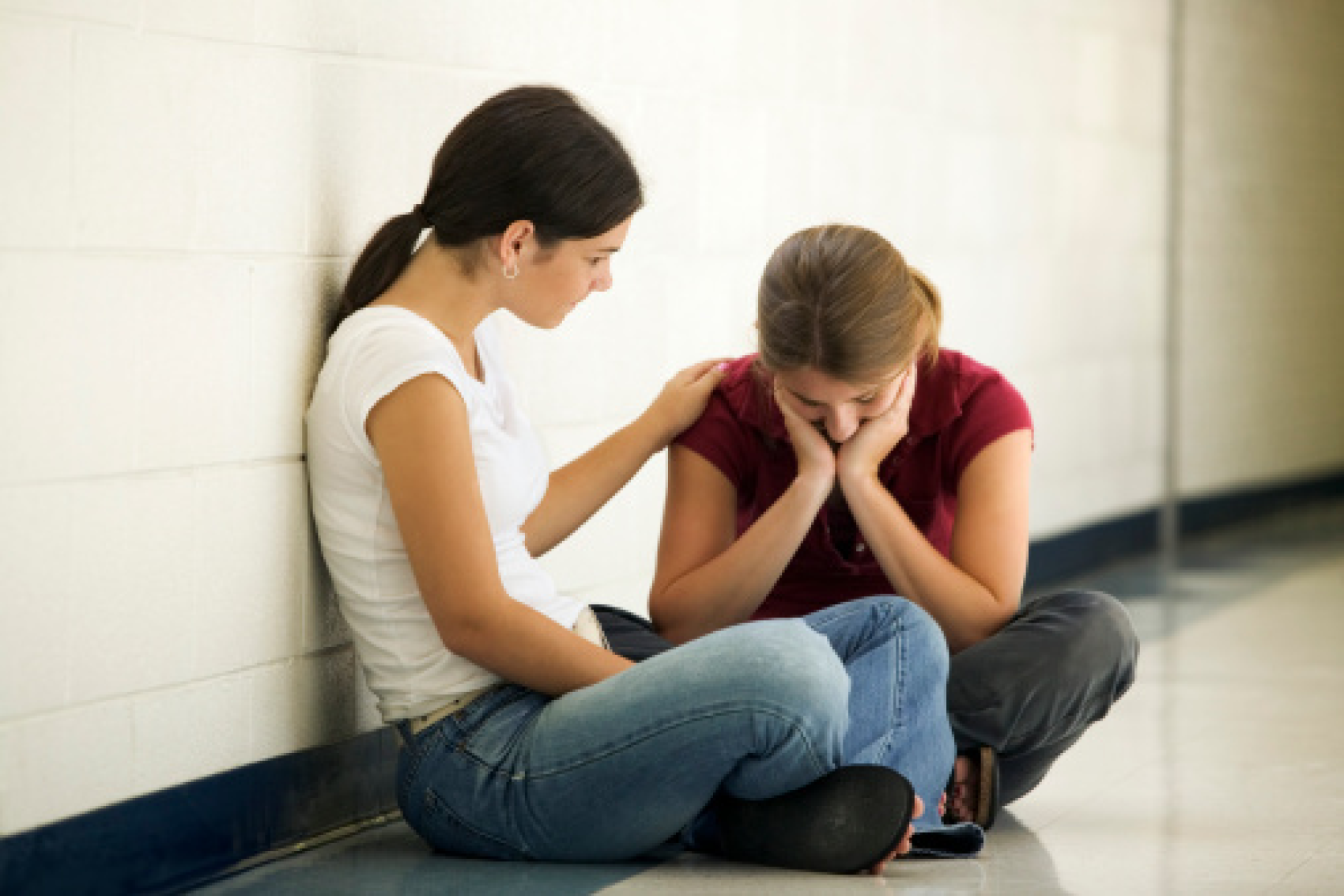 Young adult consoling depressed teenager