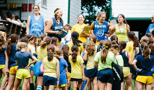 staff laughing with a group of campers