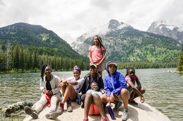 Campers on rock by lake