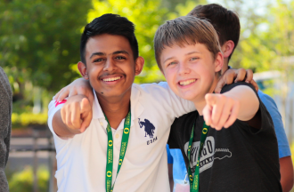 Two campers smiling and pointing at camera