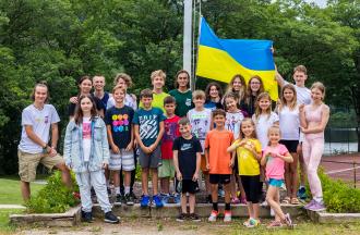 Group of Ukrainian campers standing with Ukrainian flag