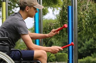 camper in wheelchair playing instrument