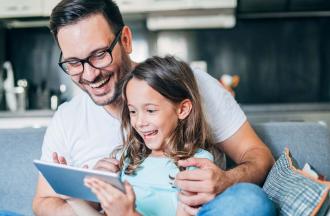stock photo of father and daughter looking at tablet