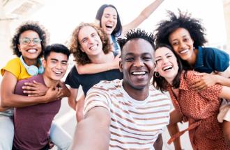 Smiling friends taking group selfie