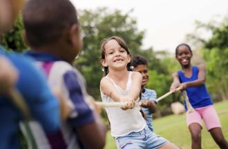 stock photo of young campers playing tug of war