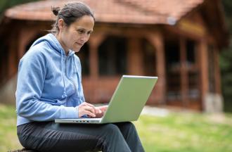 Woman working on laptop outdoors