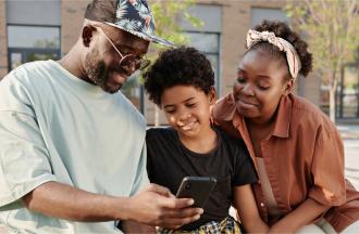 parents and child looking at phone