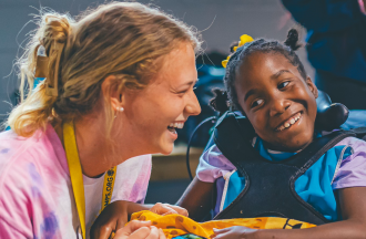 camp staff with camper who uses a wheelchair