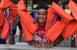 person at camp behind line of life preservers