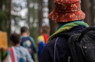 person wearing bucket hat and campers in background