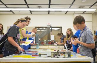 campers painting at an indoor table