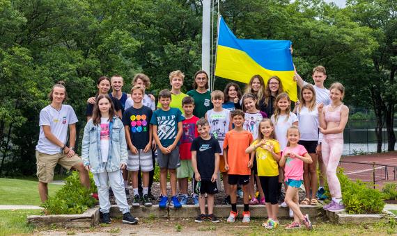 Group of Ukrainian campers standing with Ukrainian flag
