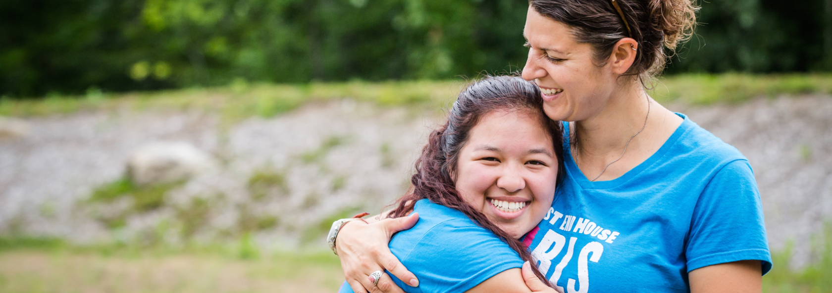 Camp director and former camper hugging