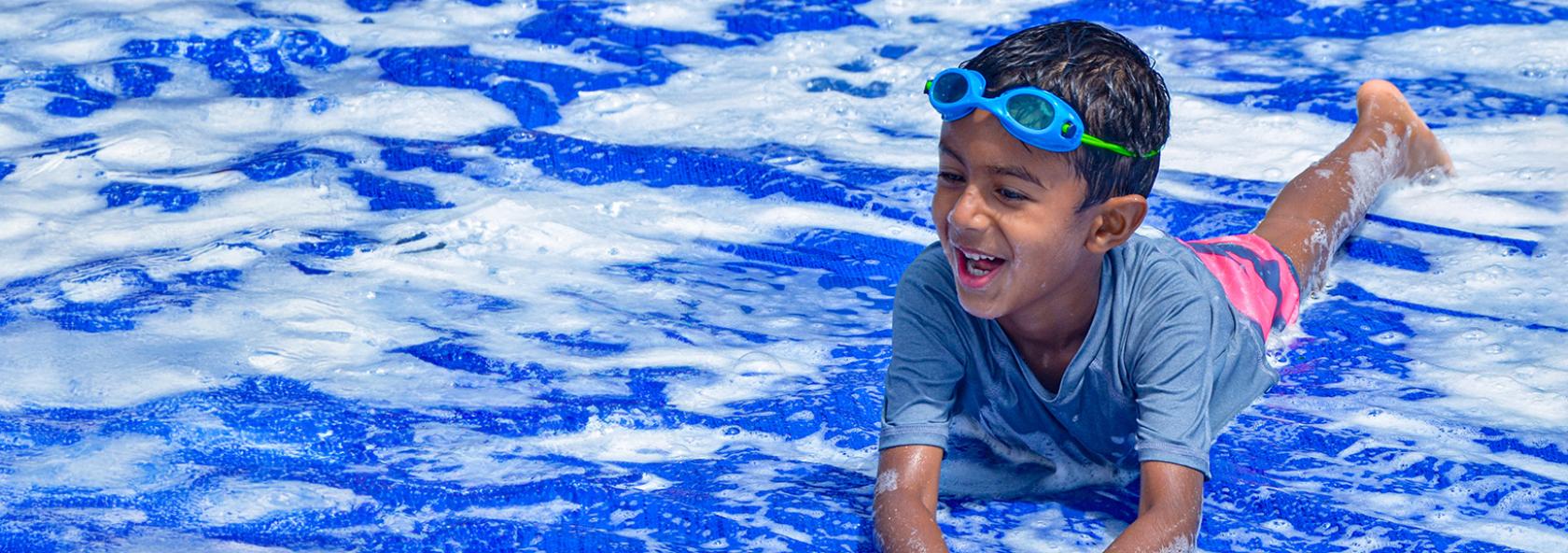 Camper smiling on soapy slip-n-slide
