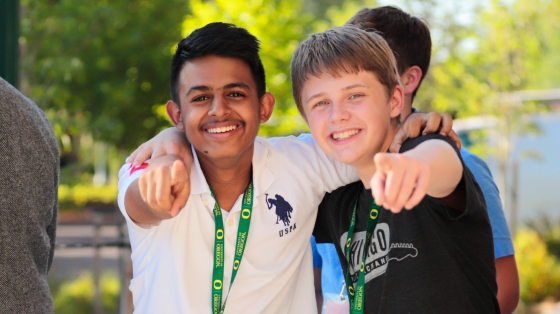 Two campers smiling and pointing at camera