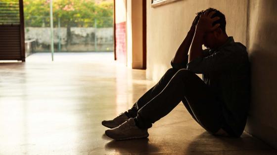 Stressed young person holding hands to head