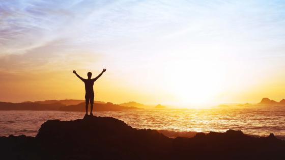 stock photo person watching sunrise over ocean