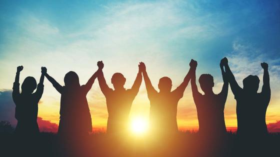 stock photo of people holding hands at sunset