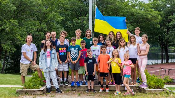 Group of Ukrainian campers standing with Ukrainian flag