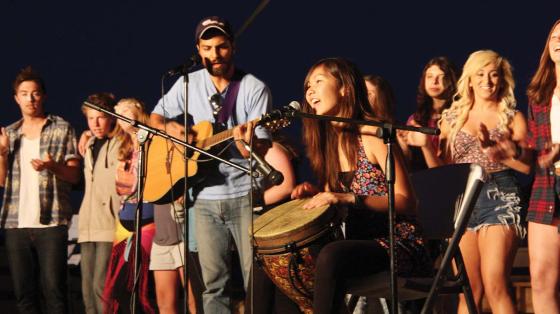 Campers and staff singing and playing music on stage