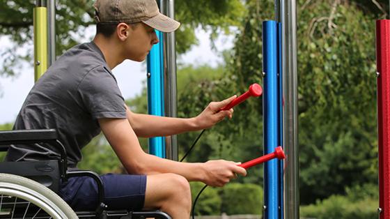 camper in wheelchair playing instrument