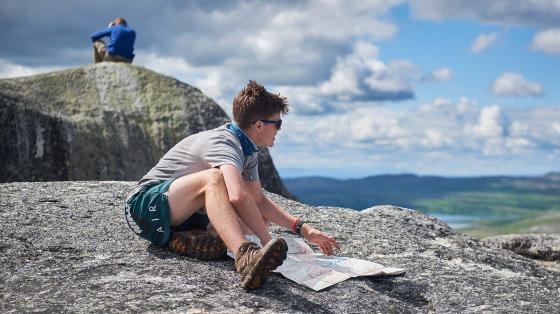 Camper reviewing trail map on top of mountain