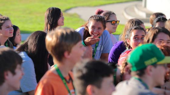 Camper laughing in a group of teen campers