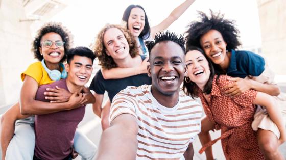 Smiling friends taking group selfie