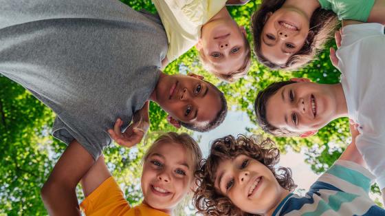 stock photo of kids huddled around camera