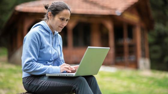 Woman working on laptop outdoors