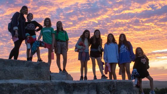 camp group in front of sunset