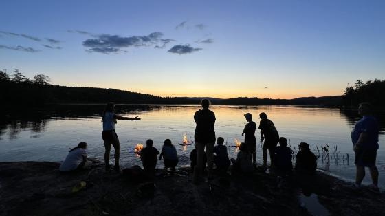 campers and staff around fires at the lake