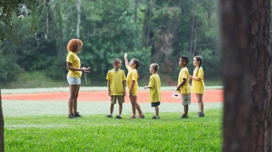 counselor with campers outdoors