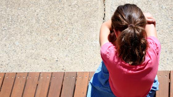 sad young girl covering her face