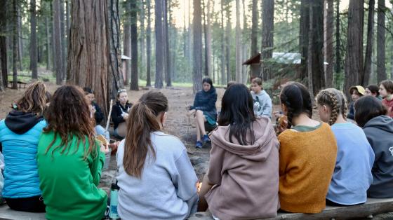 campers sitting around fire