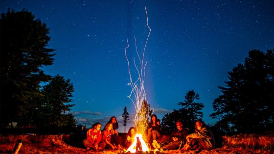 campers sitting around campfire