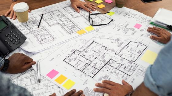 people around table looking at blueprints