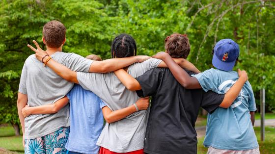 campers with back turned in a group hug