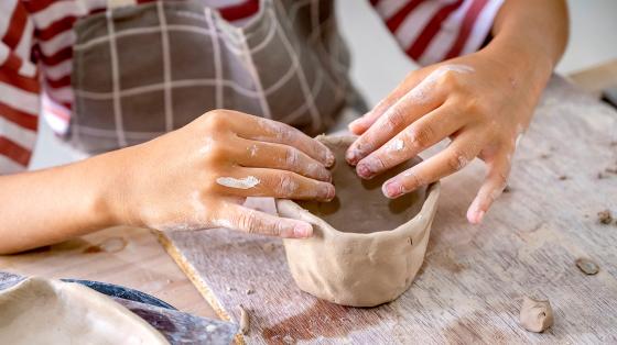 Kid forming clay with his/her hands