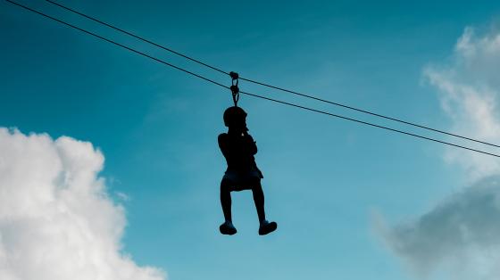silhouette of camper of zip/rope course
