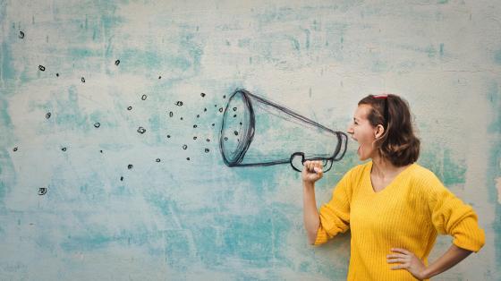female happily talking into megaphone