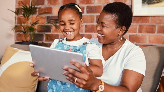photo of woman and child looking at tablet