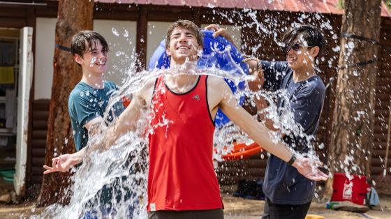 Two counselors dumping water on another