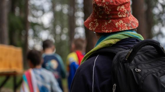 person wearing bucket hat and campers in background
