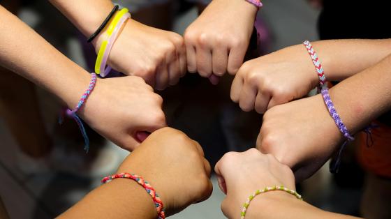 campers putting their hands in a circle